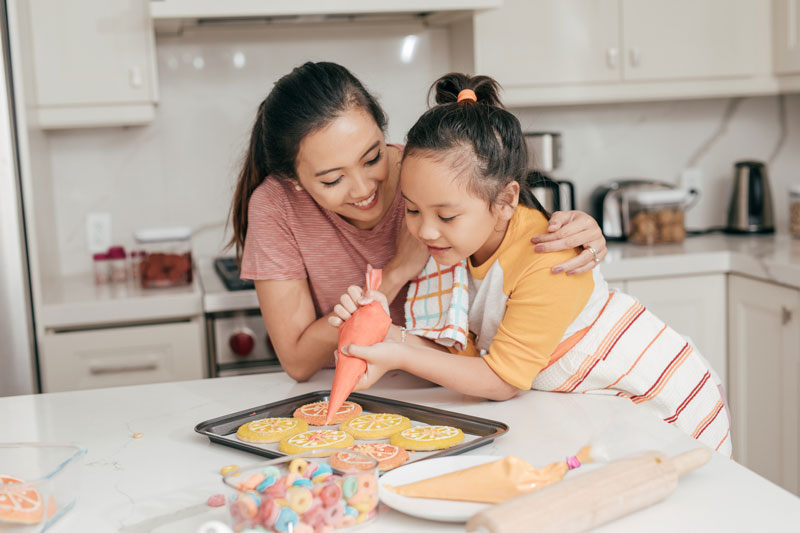 mother and child decorate cookies